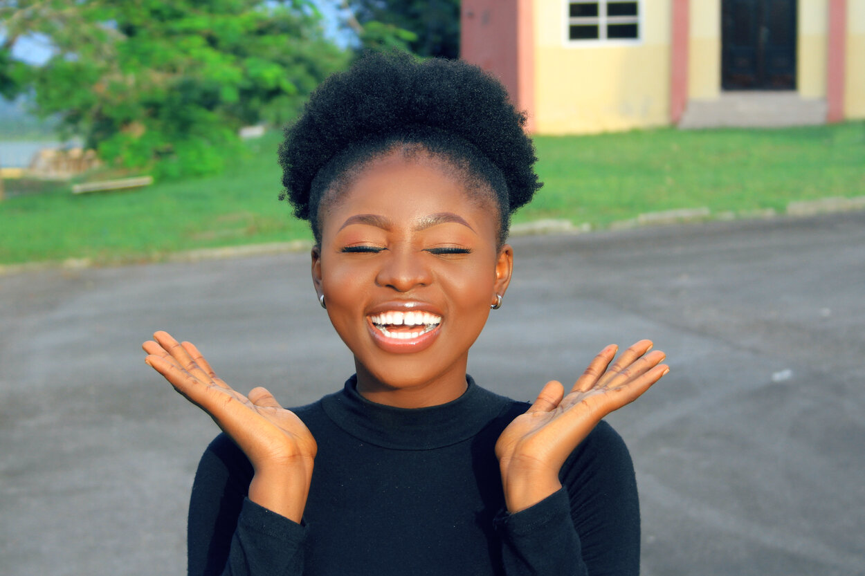 a lady standing on campus and smiling